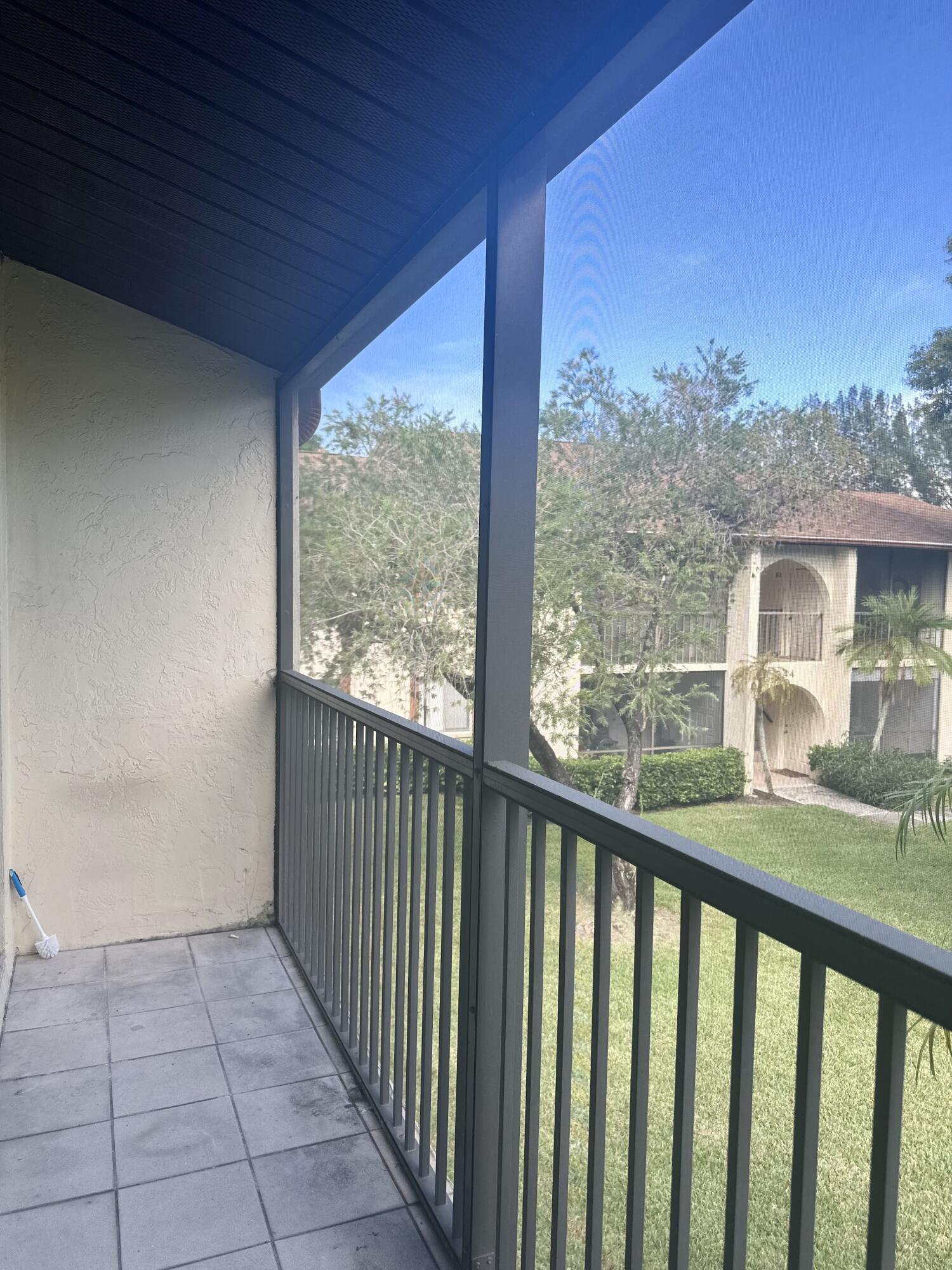 4779 Sable Pine Circle, Unit B2 West Palm Beach, FL 33417 - Photo 15 of 21 a view of a porch with a table and chairs