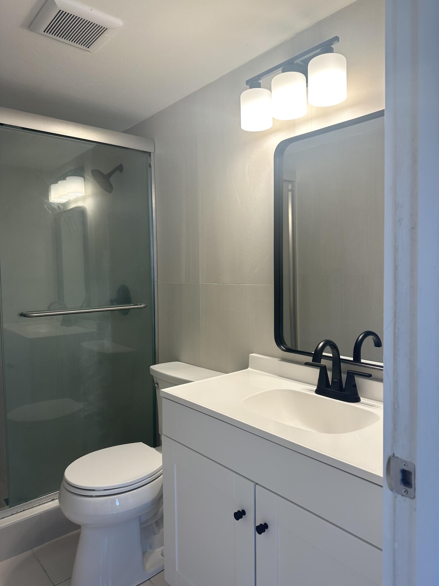 4779 Sable Pine Circle, Unit B2 West Palm Beach, FL 33417 - Photo 16 of 21 a bathroom with a sink a toilet and mirror