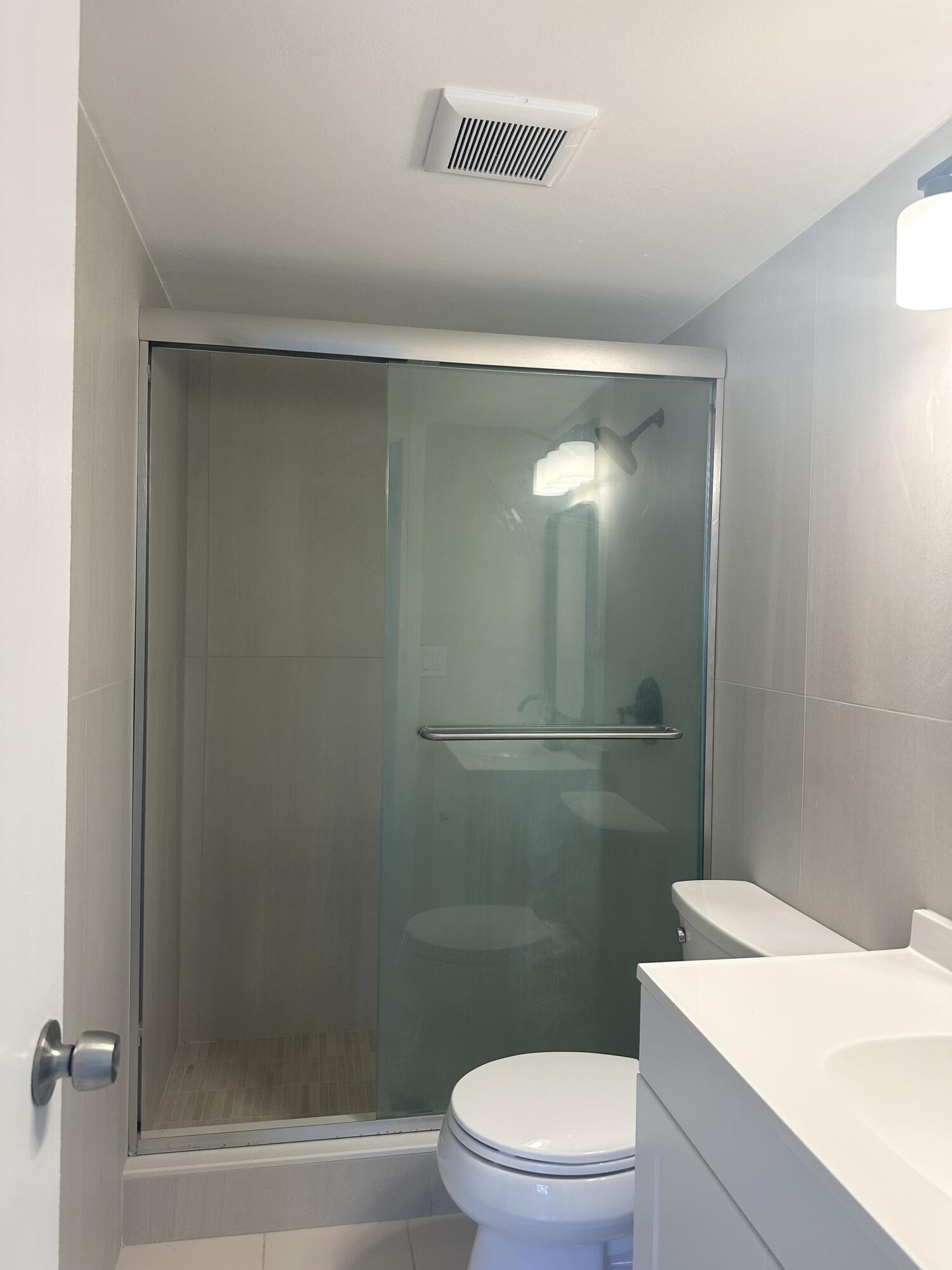 4779 Sable Pine Circle, Unit B2 West Palm Beach, FL 33417 - Photo 17 of 21 a bathroom with a sink a toilet and shower