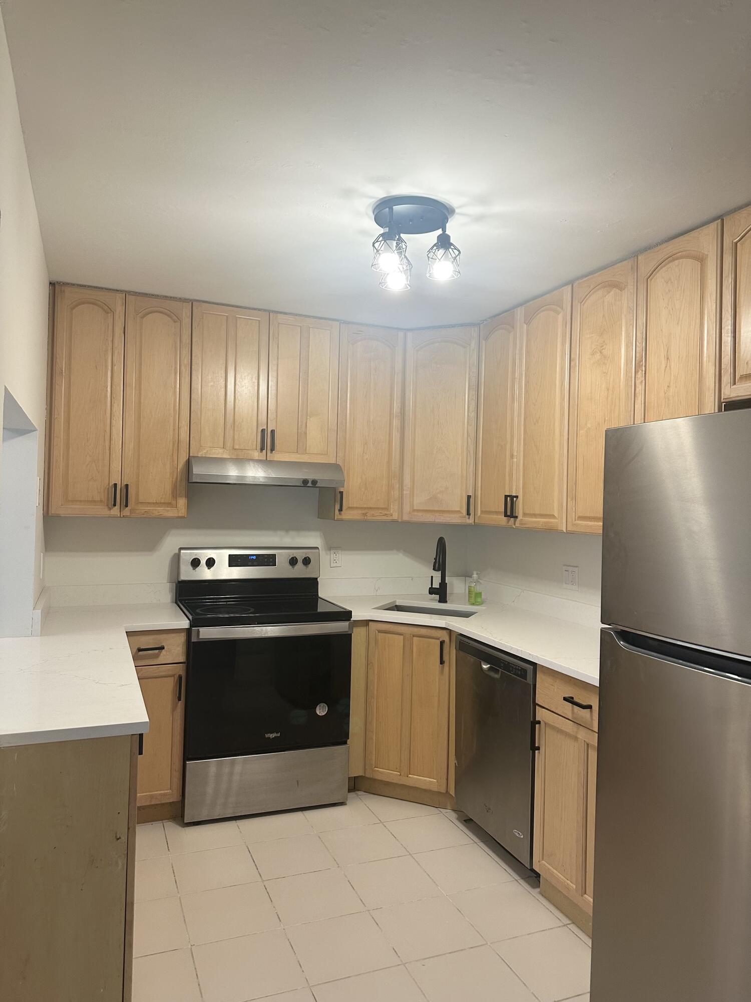 4779 Sable Pine Circle, Unit B2 West Palm Beach, FL 33417 - Photo 4 of 21 a kitchen with stainless steel appliances granite countertop a stove a refrigerator and a sink