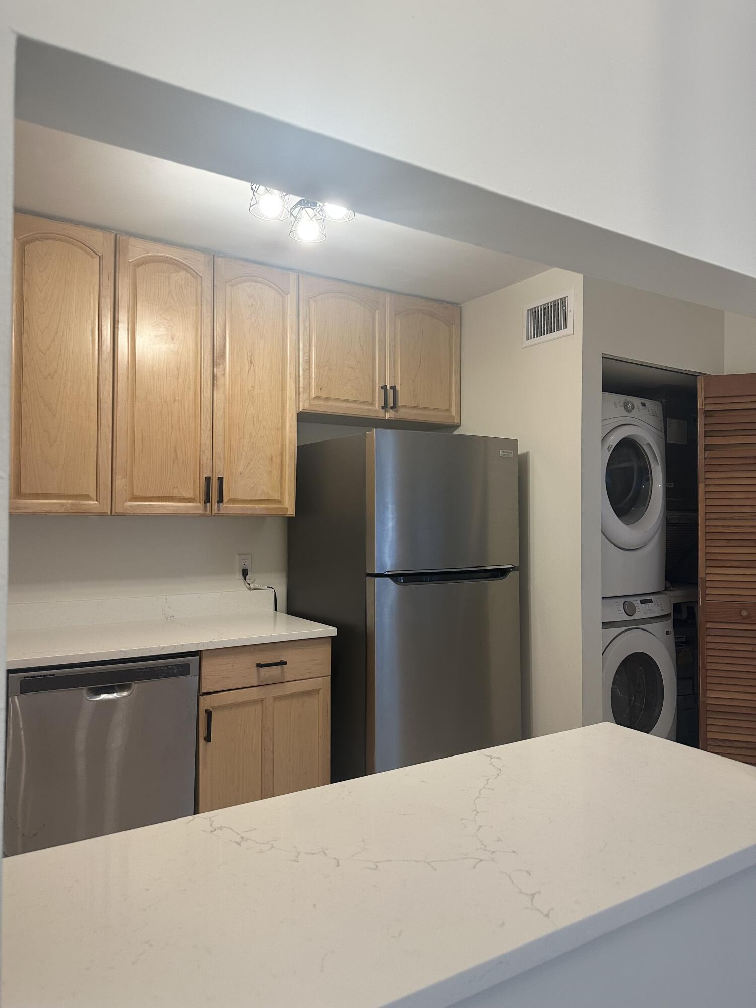 4779 Sable Pine Circle, Unit B2 West Palm Beach, FL 33417 - Photo 7 of 21 a kitchen with a refrigerator sink and cabinets