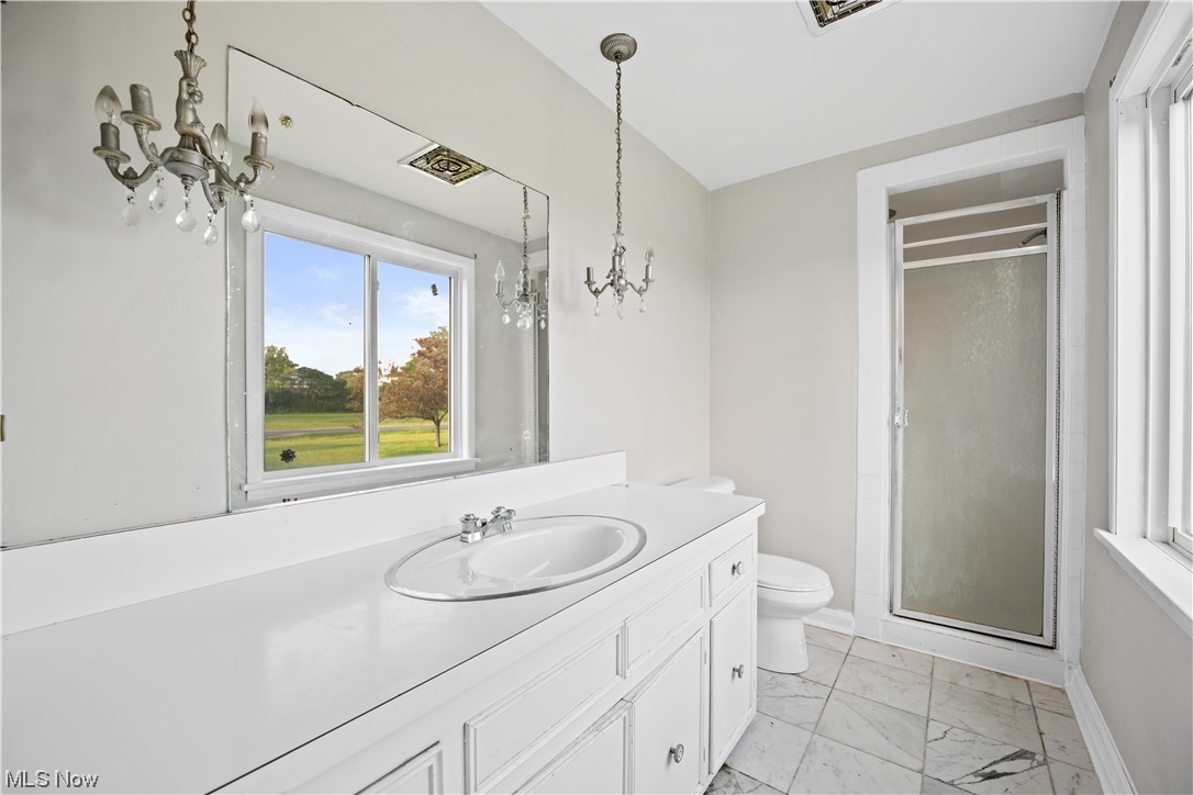 27299 Belgrave Road Cleveland, OH 44124 - Photo 9 of 11 Owners suite bathroom with vanity with extensive cabinet space, a shower with shower door, mirror, and light tile flooring