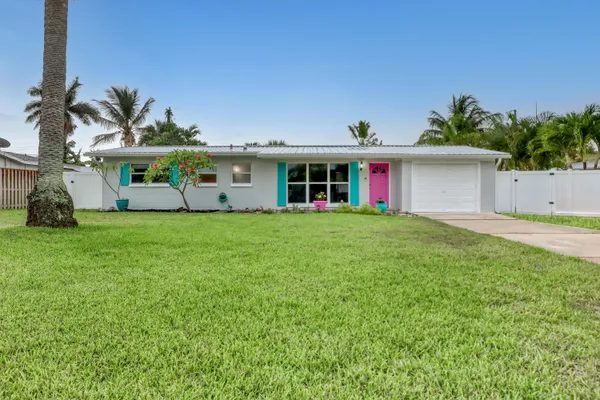 a view of a house with a yard and potted plants