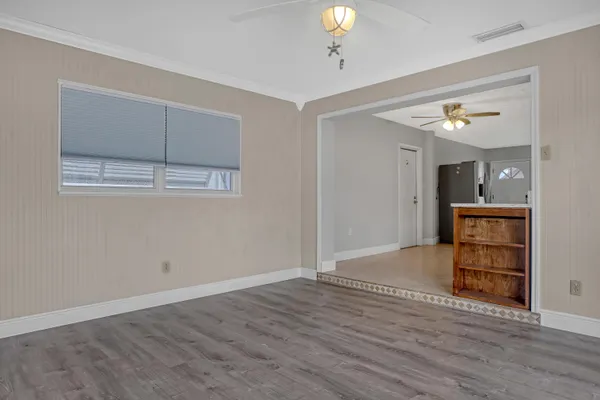 a view of empty room with wooden floor