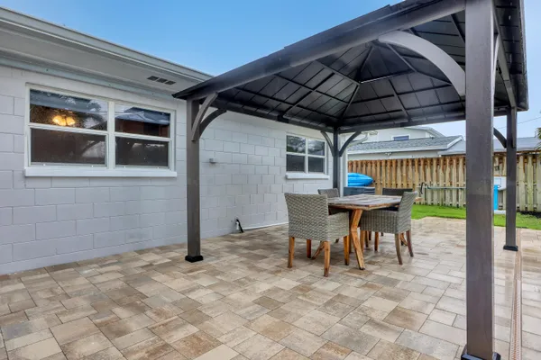 a view of roof deck with dining table and chairs under an umbrella
