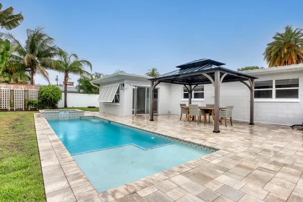 a view of a house with swimming pool and sitting area