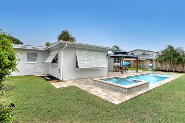 a view of a house with swimming pool and sitting area