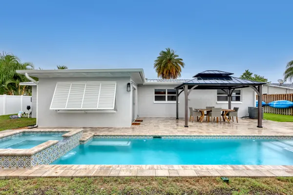 a view of backyard with swimming pool and seating space
