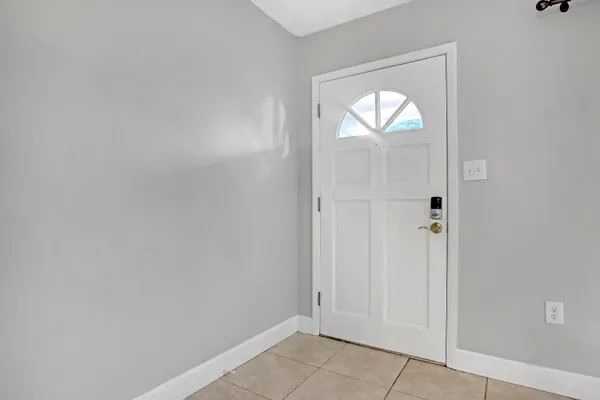 an empty room with windows and mirror