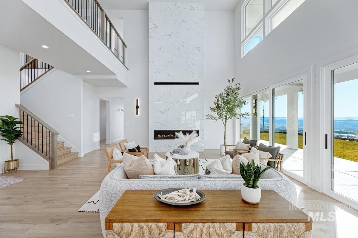 5825 East Prominence Court Boise, ID 83716 - Photo 17 of 45 Living area featuring a premium fireplace, a high ceiling, stairs, and light wood-style flooring