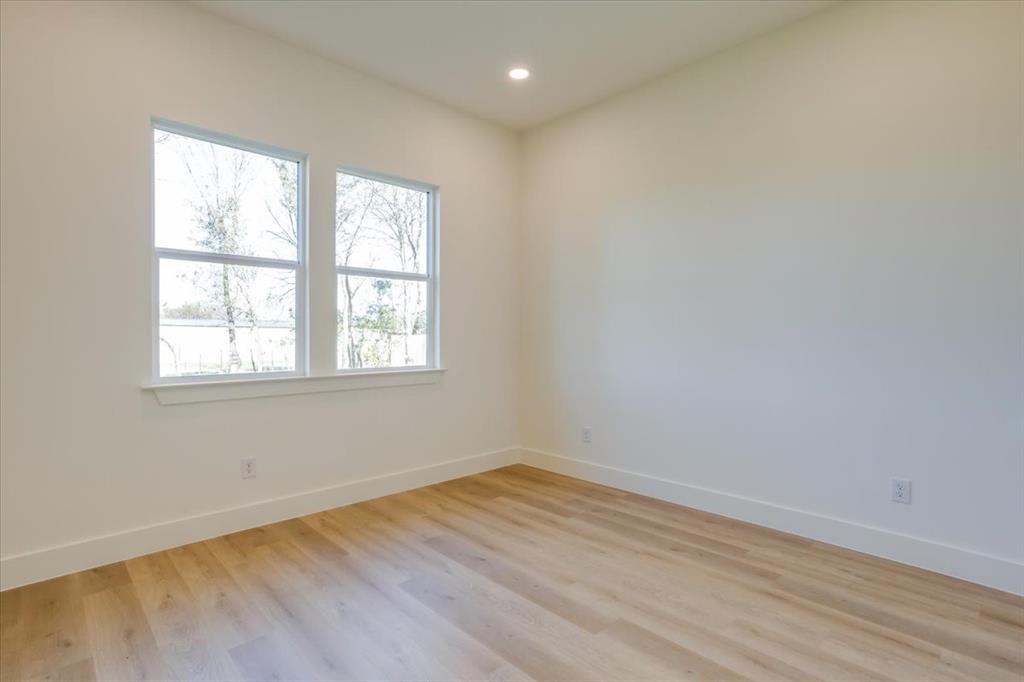 1507 Elk Creek Road Dallas, TX 75253 - Photo 23 of 40 an empty room with wooden floor and windows
