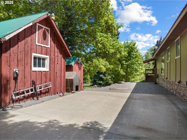 a view of a house with backyard and trees