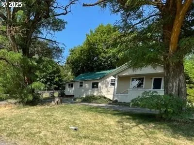 an aerial view of residential house with outdoor space and trees all around