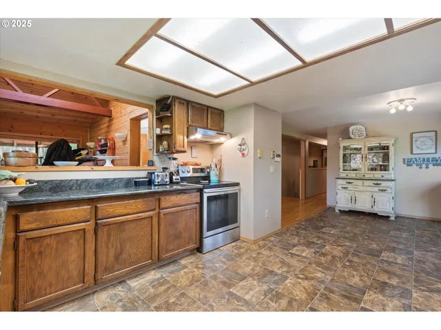a kitchen with stainless steel appliances kitchen island granite countertop a refrigerator and cabinets