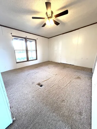 en empty room with windows and ceiling fan