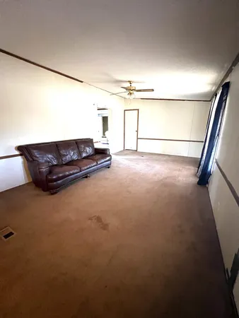 a living room with furniture and a floor to ceiling window