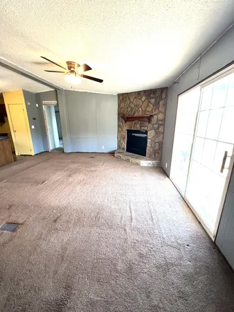 a view of empty room with fireplace and wooden floor