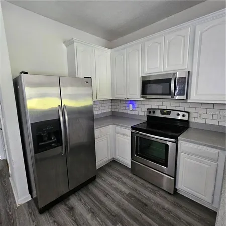 a kitchen with stainless steel appliances granite countertop a refrigerator stove and microwave