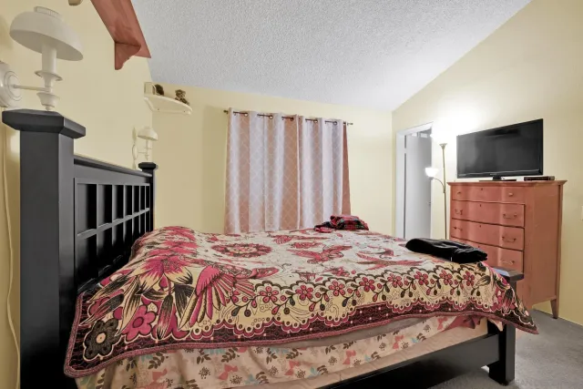 a bedroom with a bed and a flat screen tv