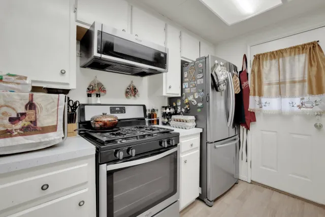 a kitchen with stainless steel appliances granite countertop a stove and a refrigerator