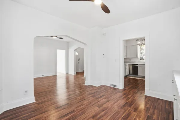 an empty room with wooden floor and windows