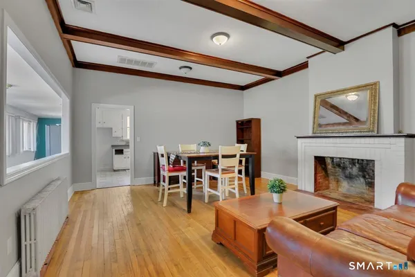 a dining room with furniture a fireplace and wooden floor