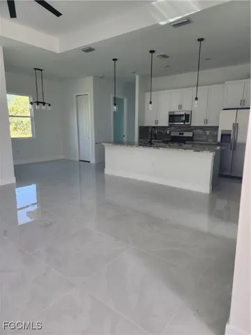 a view of a kitchen with kitchen island a sink wooden floor and glass doors