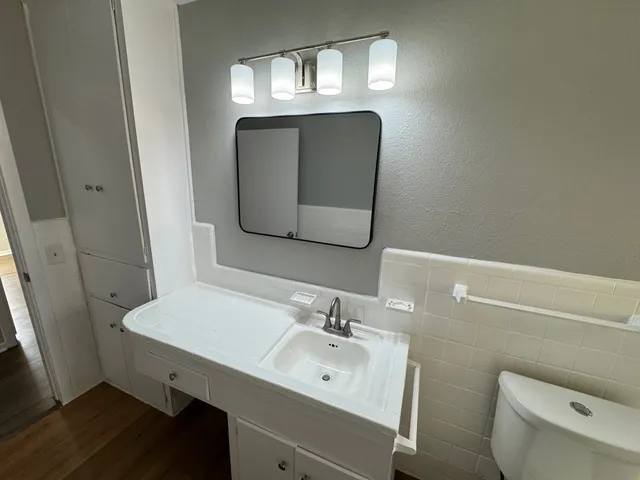 a bathroom with a toilet sink and mirror