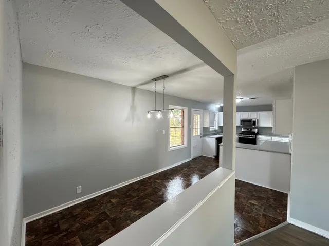 a kitchen with granite countertop white cabinets and white appliances