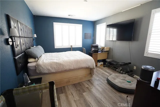 a bedroom with a bed and wooden floor