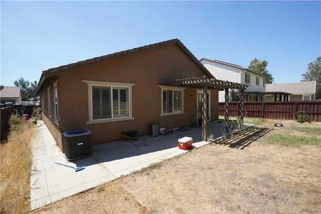 a backyard of a house with wooden fence and a bench