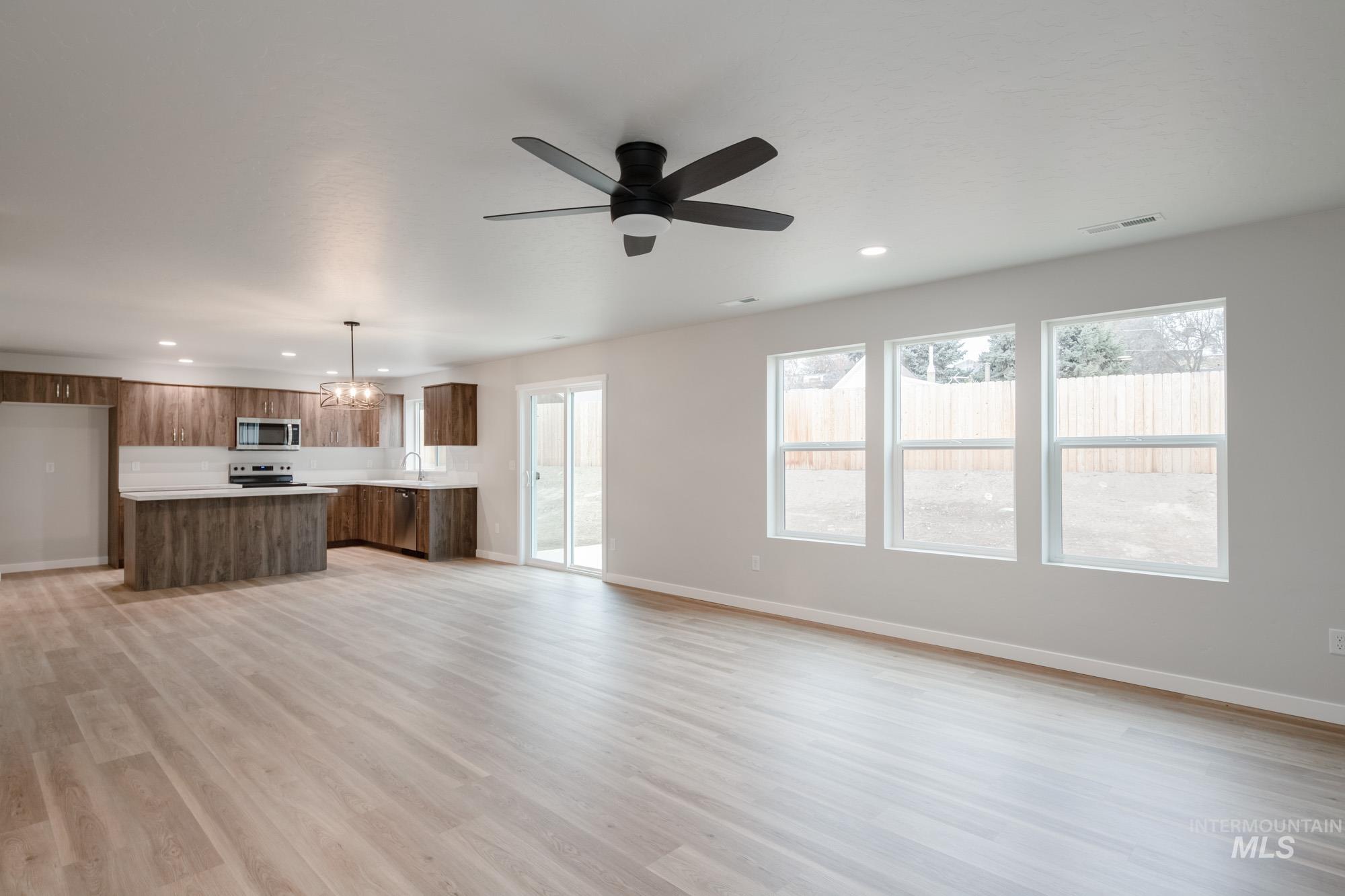 1494 Long Pond Street Middleton, ID 83644 - Photo 11 of 24 Unfurnished living room featuring recessed lighting, light wood finished floors, a chandelier, and ceiling fan