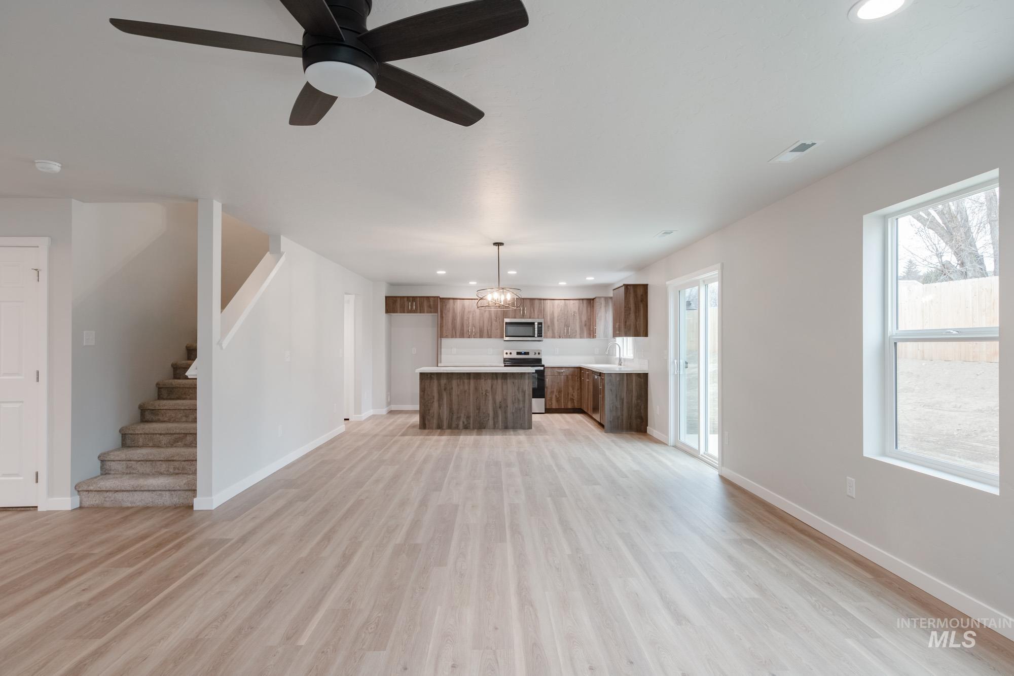 1494 Long Pond Street Middleton, ID 83644 - Photo 13 of 25 Unfurnished living room featuring recessed lighting, ceiling fan, stairway, and light wood-style flooring