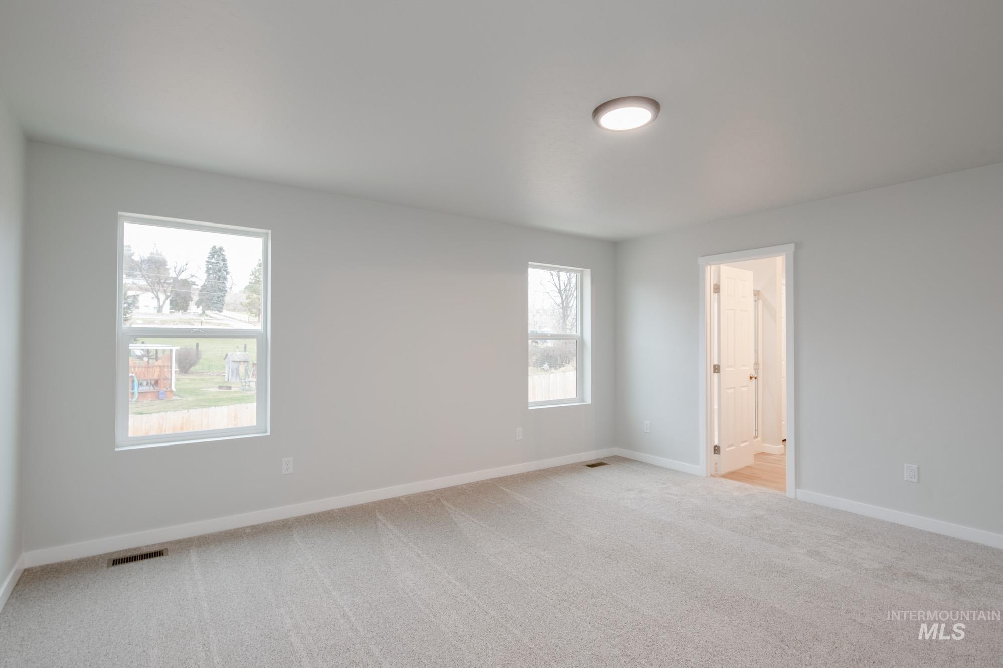 1494 Long Pond Street Middleton, ID 83644 - Photo 23 of 25 Empty room with light colored carpet and baseboards