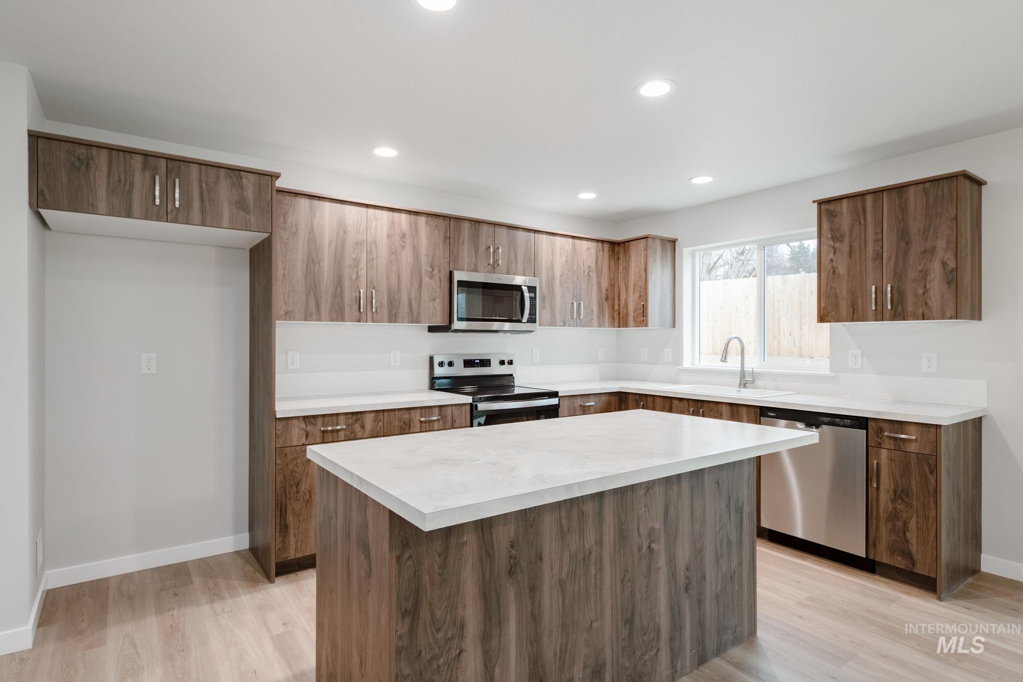1494 Long Pond Street Middleton, ID 83644 - Photo 4 of 25 Kitchen with appliances with stainless steel finishes, light countertops, a center island, light wood finished floors, and recessed lighting