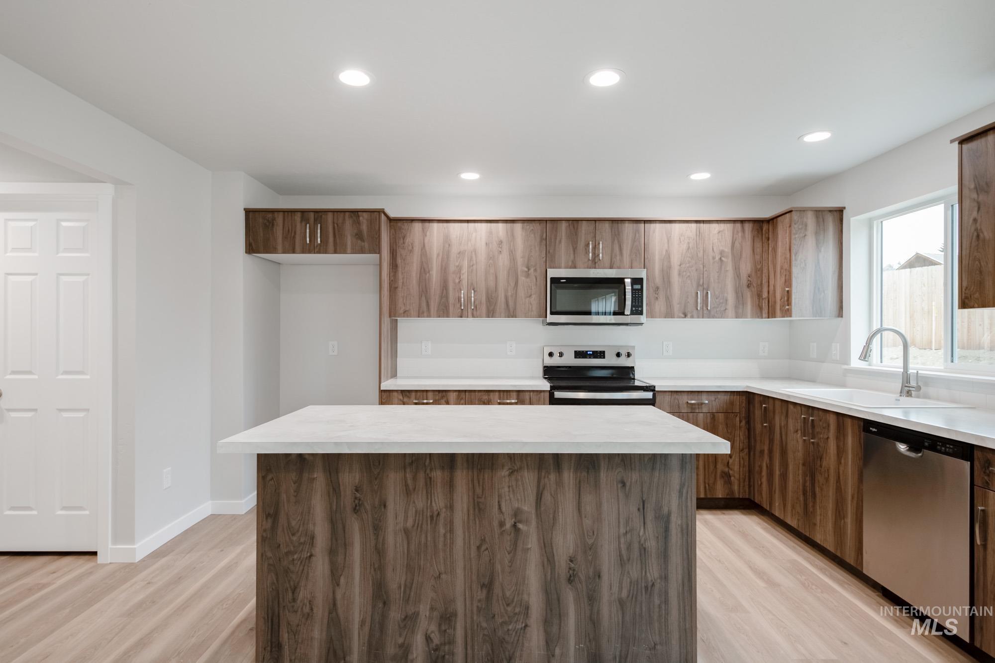 1494 Long Pond Street Middleton, ID 83644 - Photo 4 of 24 Kitchen with stainless steel appliances, light countertops, a kitchen island, recessed lighting, and light wood-type flooring