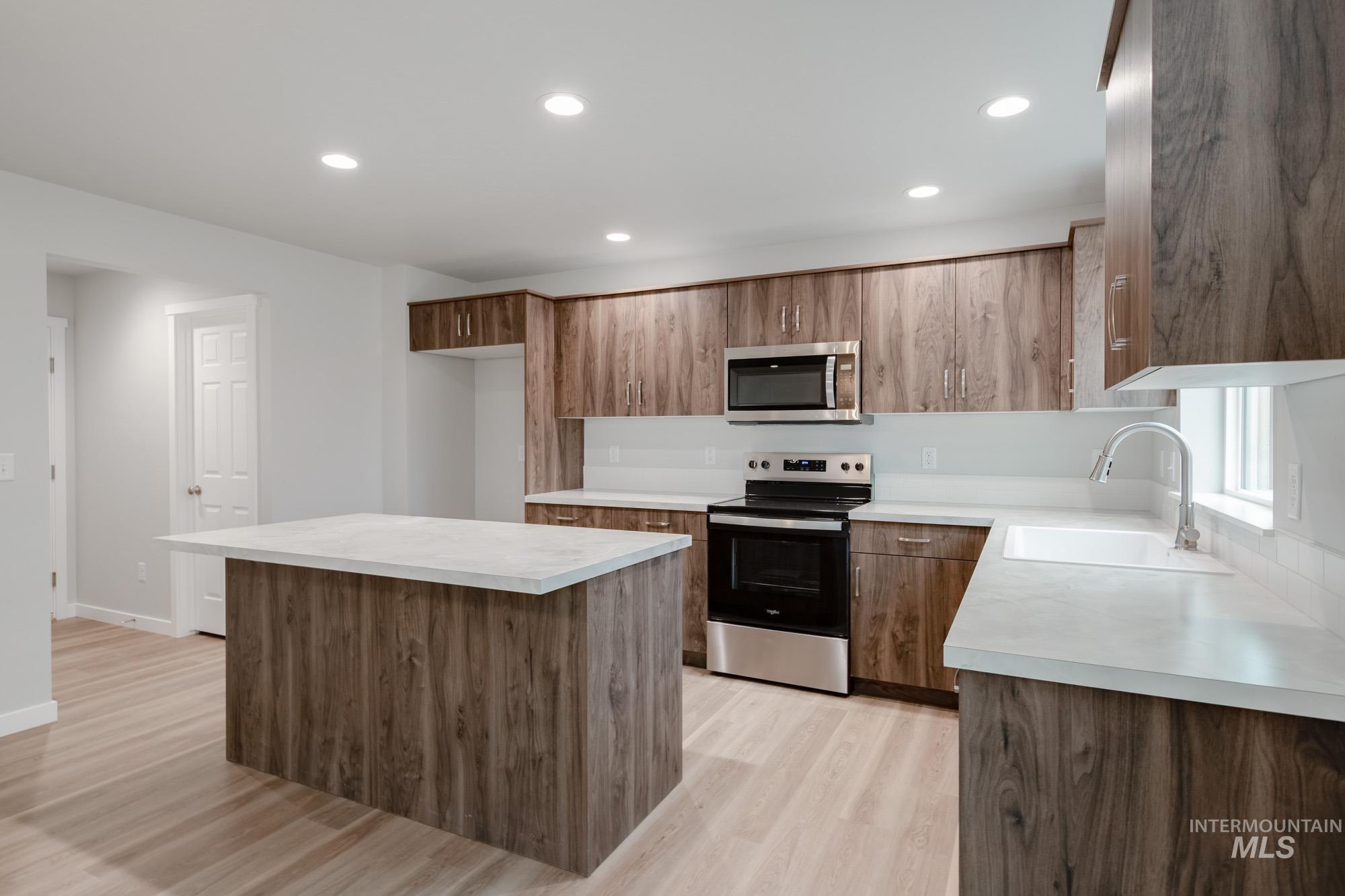1494 Long Pond Street Middleton, ID 83644 - Photo 6 of 25 Kitchen with stainless steel appliances, a kitchen island, recessed lighting, light countertops, and light wood-style flooring
