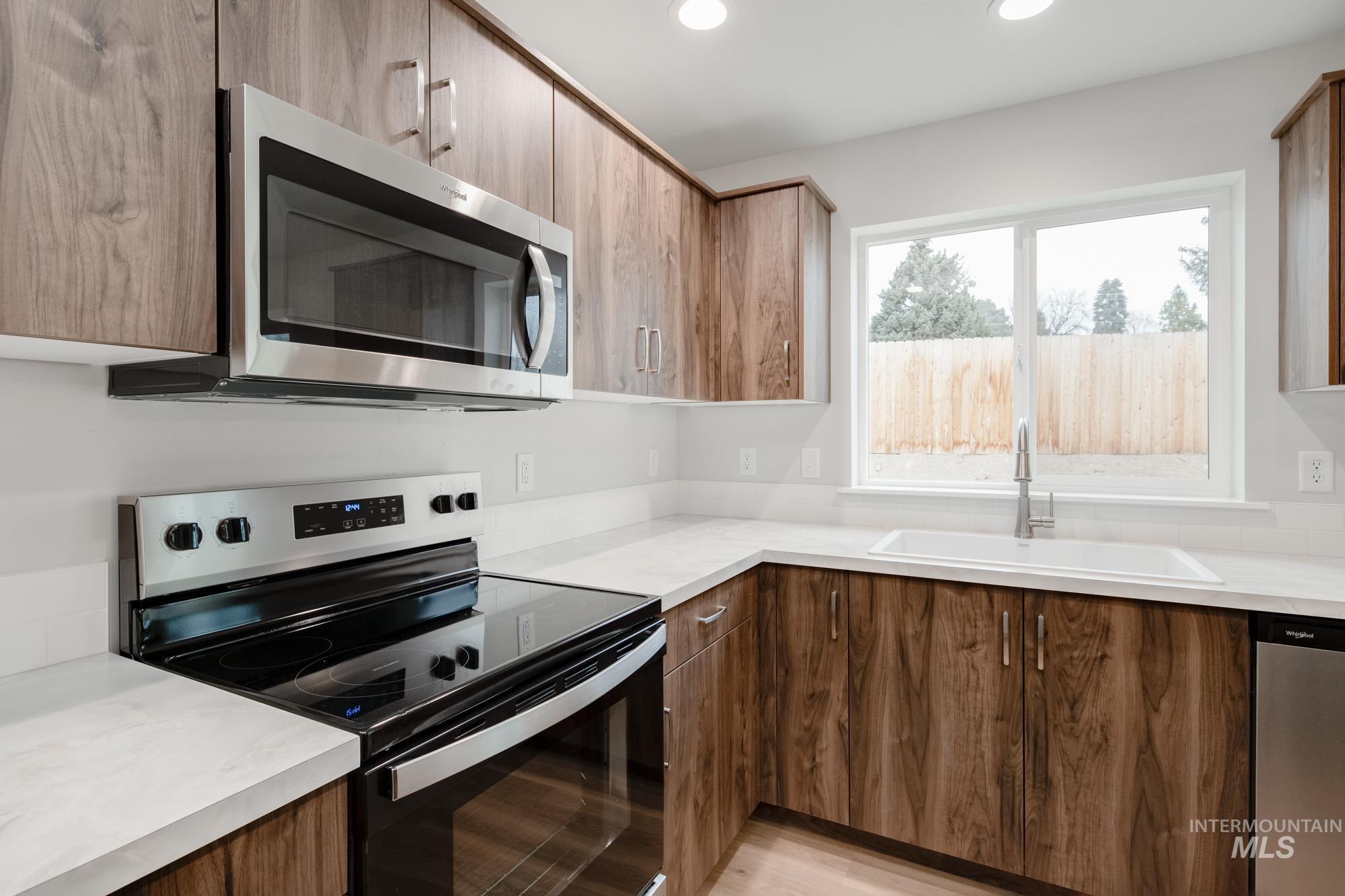 1494 Long Pond Street Middleton, ID 83644 - Photo 7 of 25 Kitchen featuring appliances with stainless steel finishes, light countertops, recessed lighting, light wood-type flooring, and modern cabinets