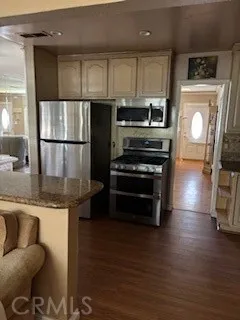 a kitchen with kitchen island granite countertop a stove a sink and a refrigerator