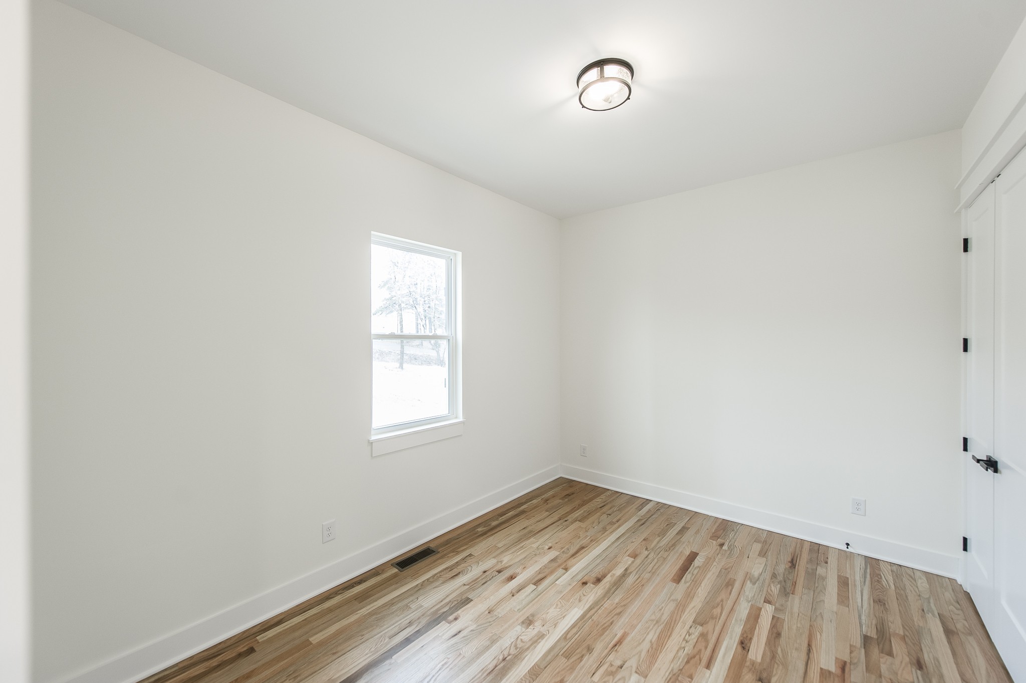 2026 Beaver Ridge Road Burns, TN 37029 - Photo 25 of 45 an empty room with wooden floor and windows