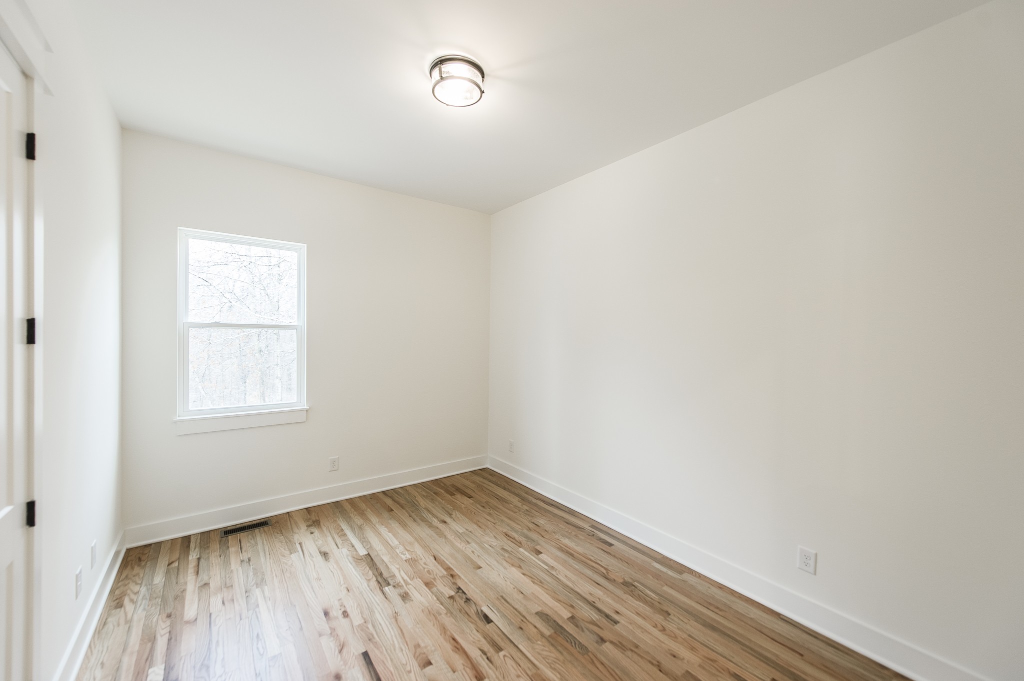 2026 Beaver Ridge Road Burns, TN 37029 - Photo 29 of 45 an empty room with wooden floor and windows