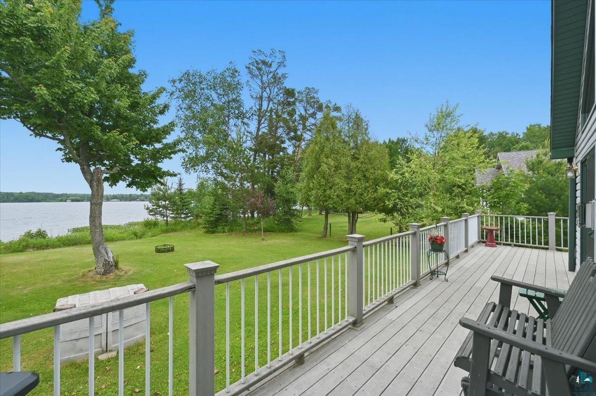 8162 South Dowling Road West Superior, WI 54880 - Photo 12 of 15 Expansive outdoor deck with composite decking and white railings, overlooking a verdant lawn and a large body of water