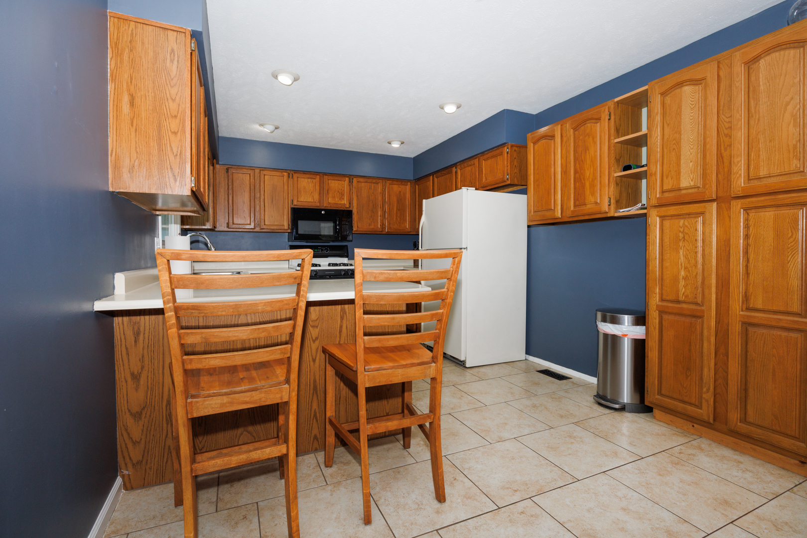 107 Regal Drive Normal, IL 61761 - Photo 11 of 41 a kitchen with a refrigerator a stove cabinets and a dining table