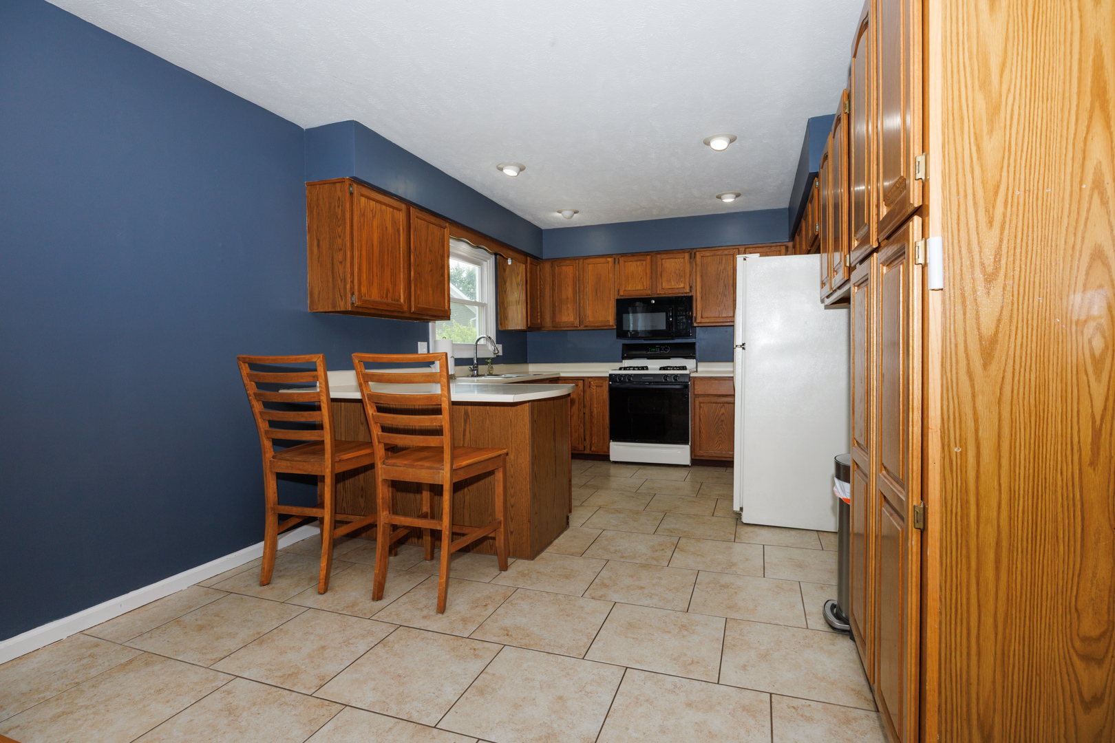 107 Regal Drive Normal, IL 61761 - Photo 9 of 41 a kitchen with a sink a counter and chairs
