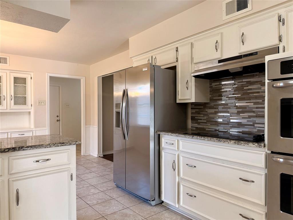 4737 Thunder Road Dallas, TX 75244 - Photo 6 of 17 a kitchen with granite countertop white cabinets and stainless steel appliances