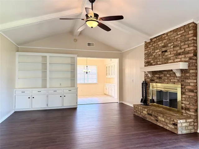 a view of an empty room with cabinet and a fireplace