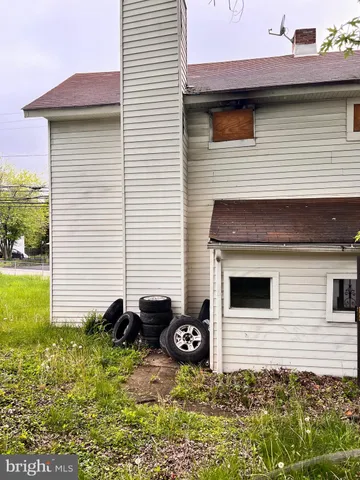 a view of a white house with a large tree