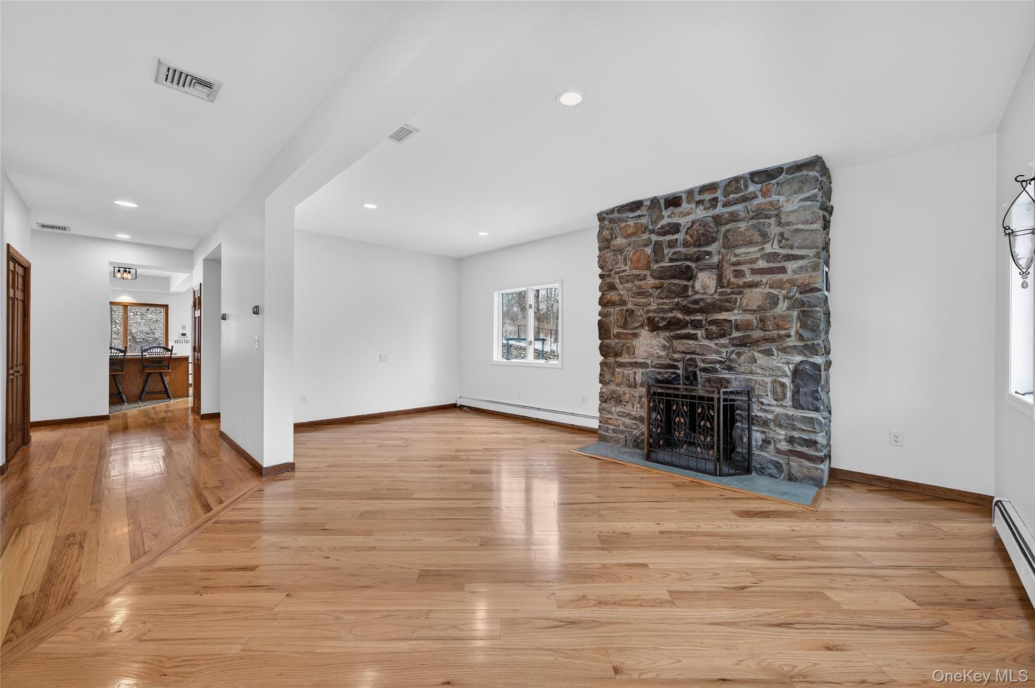 558 Pine Hill Road Chester, NY 10918 - Photo 11 of 50 Unfurnished living room featuring light wood-type flooring, a fireplace, a baseboard radiator, a baseboard heating unit, and recessed lighting