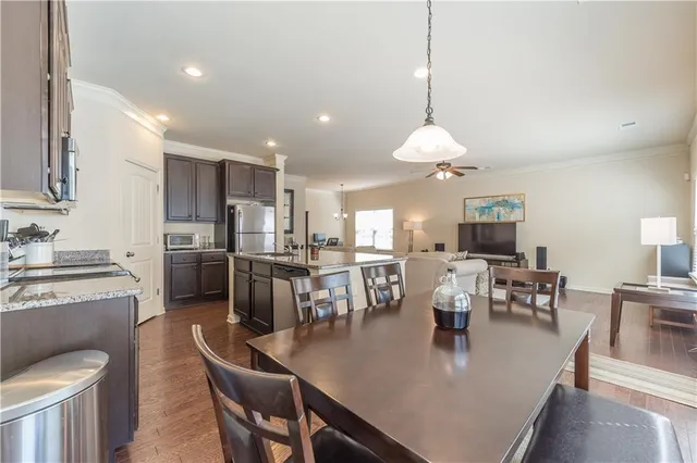 a view of a dining room and livingroom with furniture wooden floor a chandelier