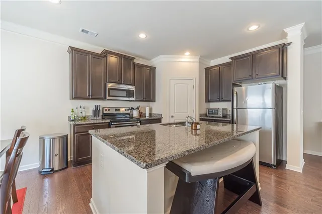 a kitchen with kitchen island a counter top space cabinets and stainless steel appliances